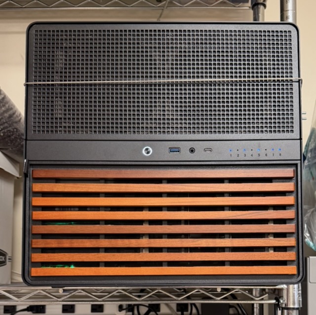 The computer sits on a shelf in the garage, with a cable around it for earthquake safety.